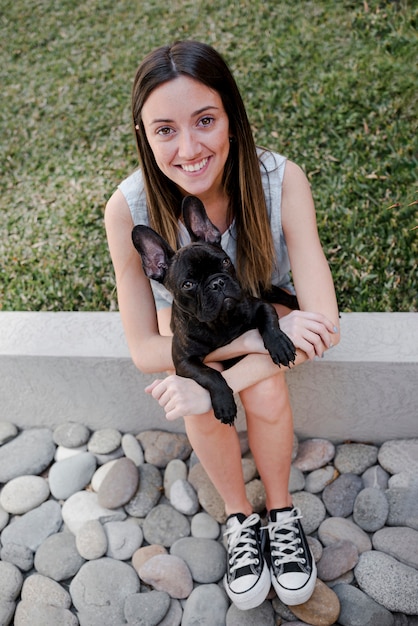 Бесплатное фото Высокий угол девушка держит ее щенка