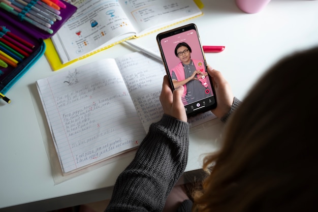 Free photo high angle girl holding smartphone