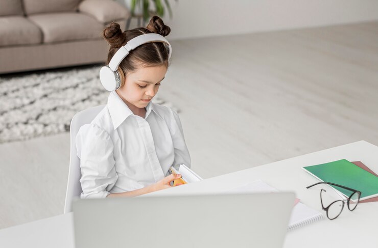 Free Photo high angle girl listening to her teacher through headphones