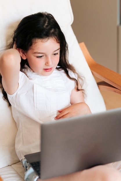 High angle girl looking at the laptop