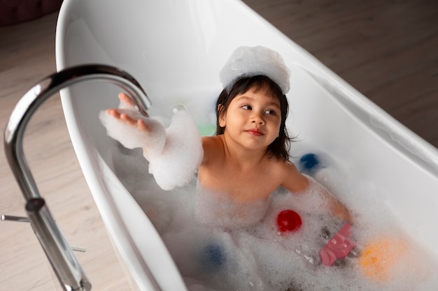 High angle girl playing in bathtub