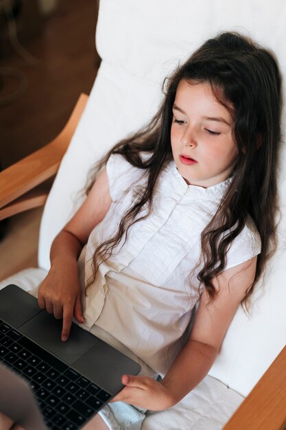 ノートパソコンで座っているハイアングルの女の子