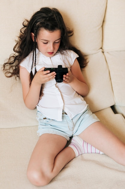 High angle girl with braids and photo camera