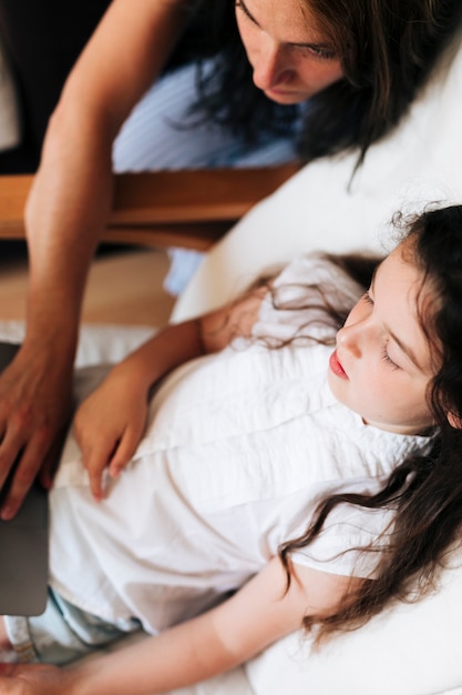 High angle girl with mother looking at laptop