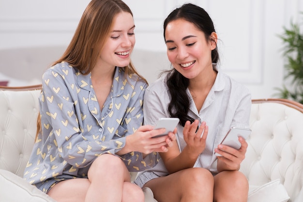 Amiche dell'angolo alto che guardano sul cellulare