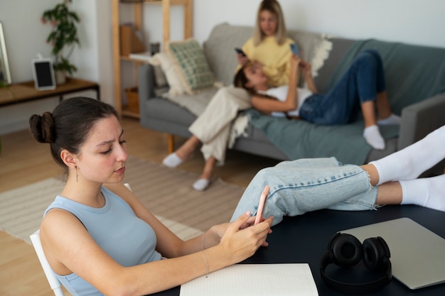 Foto gratuita ragazze ad alto angolo con dipendenza da smartphone