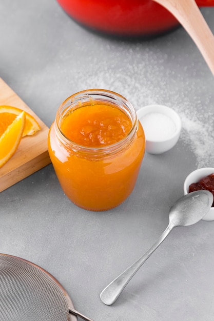 High angle of glass jar with orange jam