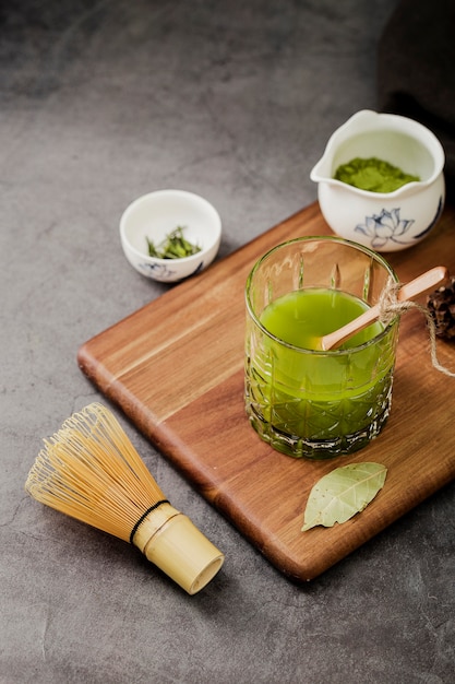 High angle of glass of matcha tea on chopping board
