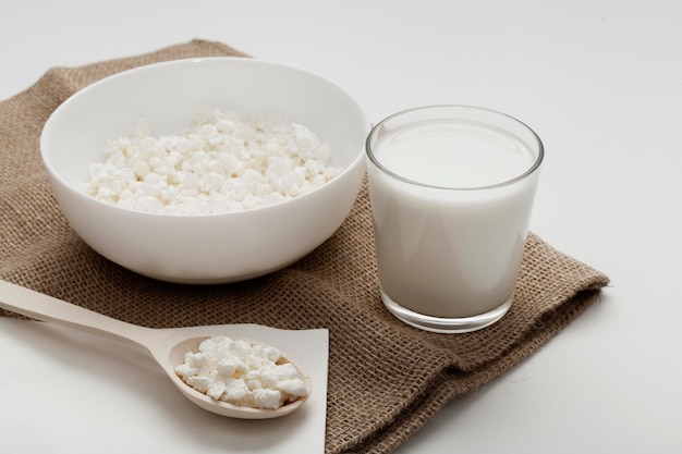 Free photo high angle glass of milk next to bowl of cereal