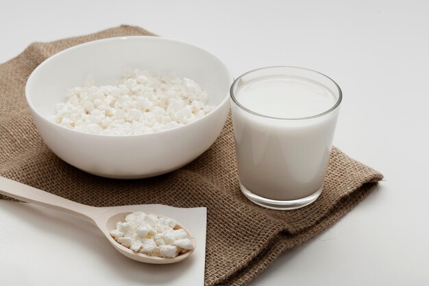 High angle glass of milk next to bowl of cereal