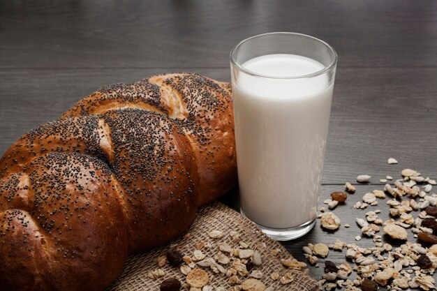 Высокий угол стакан молока рядом со свежим хлебом