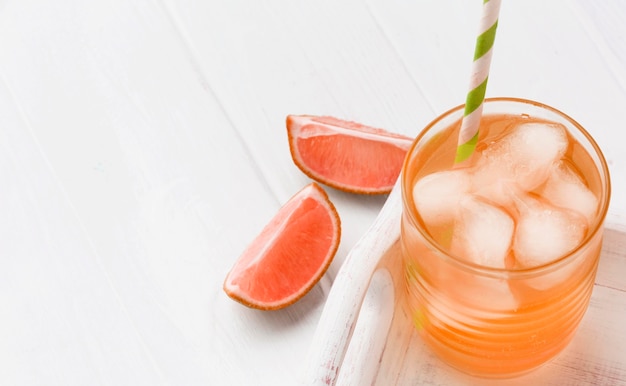 High angle of glass with soft drink and grapefruit