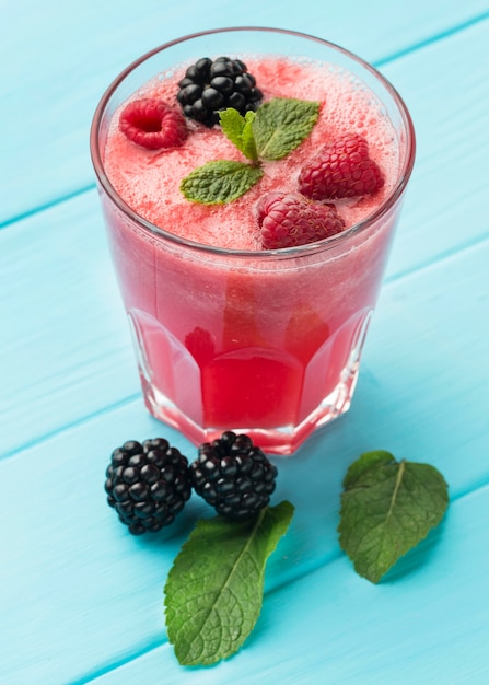 High angle of glass with watermelon cocktail and fruit