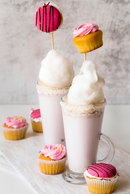 High angle of glasses of dessert with muffins