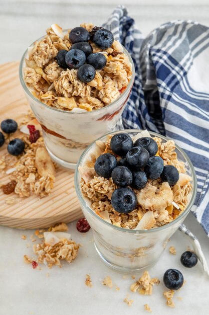 High angle of glasses with breakfast cereals and yogurt with fruits