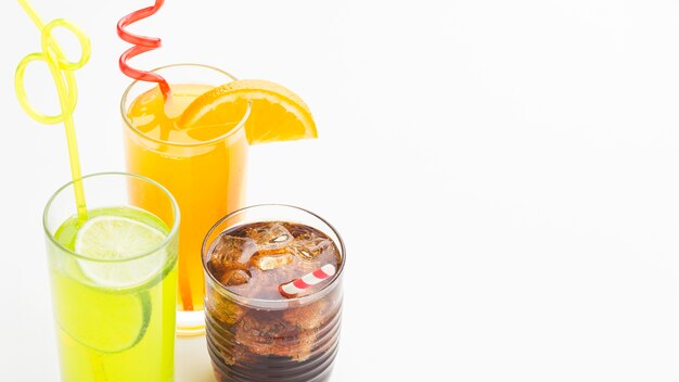 High angle of glasses with soft drinks and straws