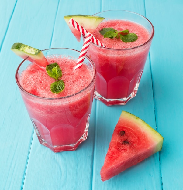 High angle of glasses with straws and watermelon cocktails