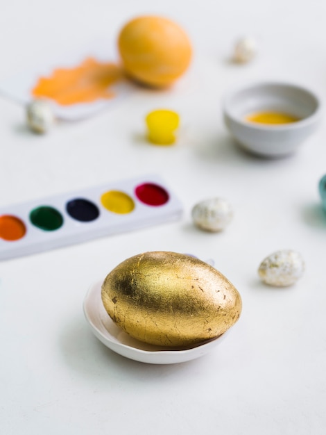 High angle of golden easter egg with defocused palette