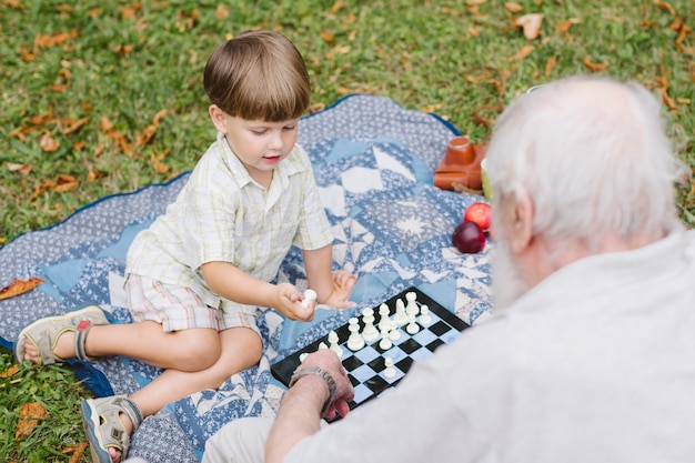 Grandangolo nonno e nipote che giocano a scacchi