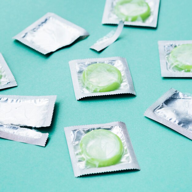 Высокий угол зеленые презервативы на зеленом фоне