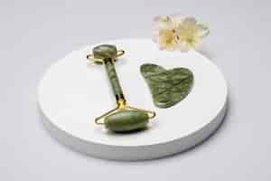 Free photo high angle gua sha and flower arrangement