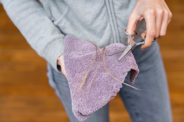 Free photo high angle of hairdresser holding cloth and scissors with tuft of hair