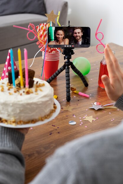Рука под высоким углом держит торт ко дню рождения