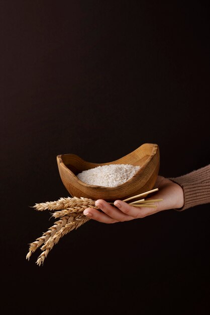 High angle hand holding bowl with rice and grains