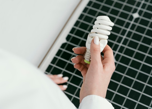 High angle hand holding eco lightbulb