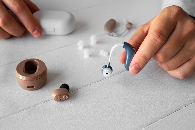 high angle hand holding hearing aids