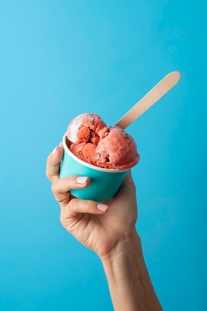 high angle hand holding ice cream cup