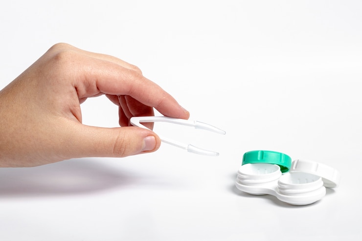 Free Photo high angle of hand holding tweezers for contact lenses