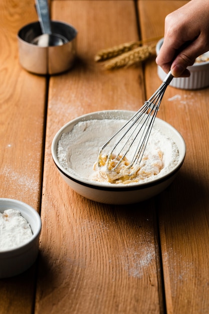 High angle of a hand mixing egg and flour