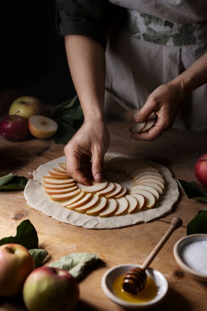 반죽에 사과 조각을 넣는 하이 앵글 손