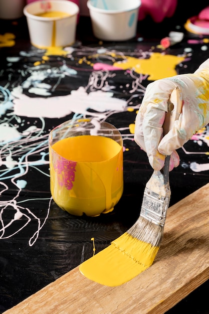 High angle of hand with glove painting with brush