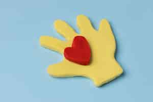 Free photo high angle hand with play dough red heart