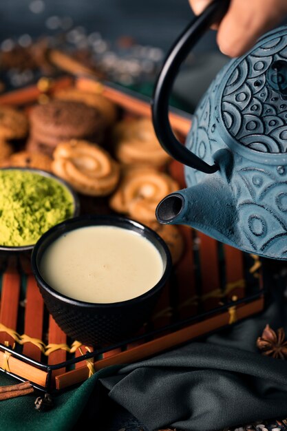 High angle hand with teapot pouring drink