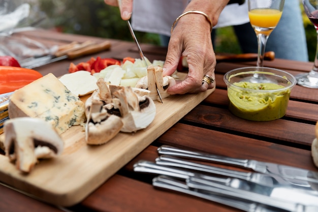 Foto gratuita mani ad alto angolo che tagliano i funghi