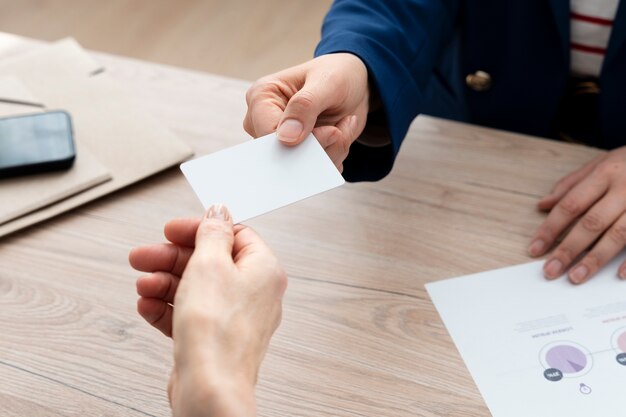 High angle hands holding business cards