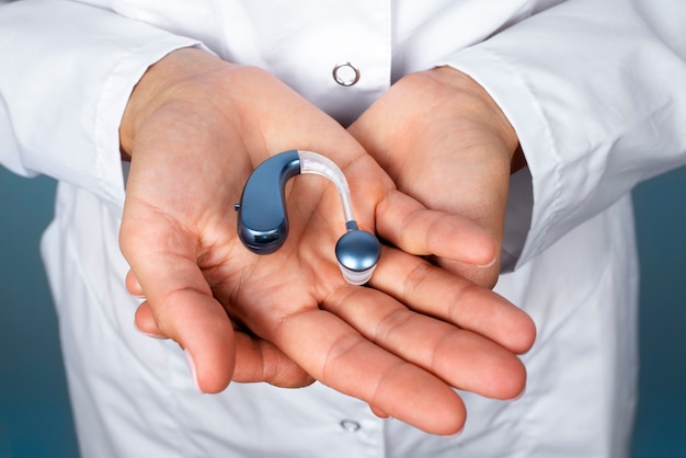 Free photo high angle hands holding hearing aids