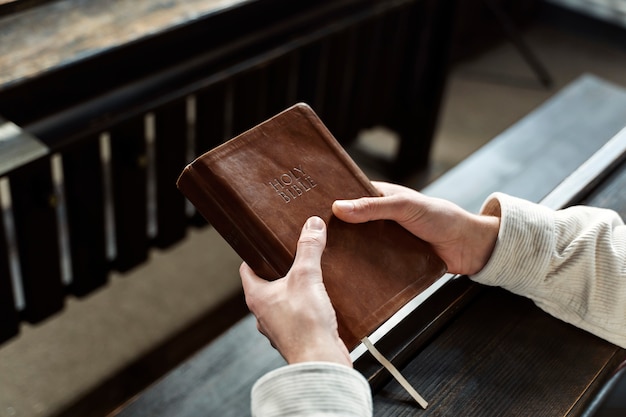 Foto gratuita mani ad alto angolo che tengono la sacra bibbia