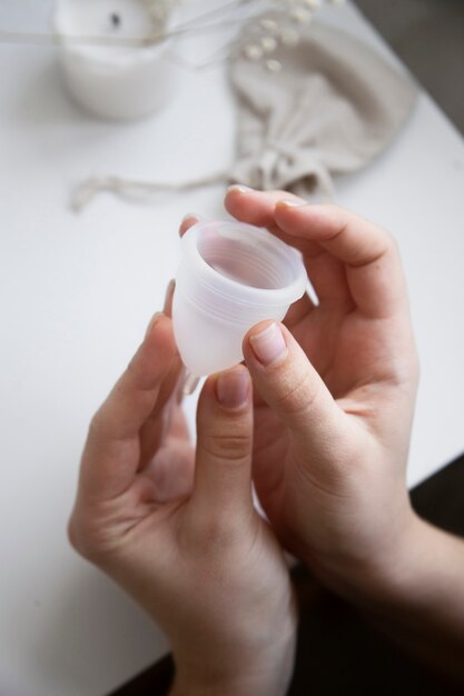 High angle hands holding menstrual cup