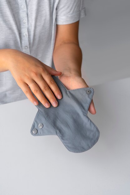 High angle hands holding menstrual pad