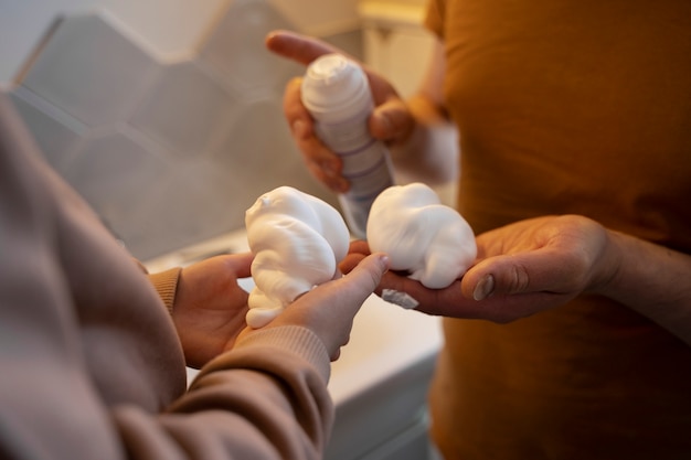 Mani ad alto angolo che tengono la crema da barba