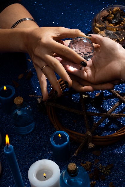 Free photo high angle hands holding small crystal ball