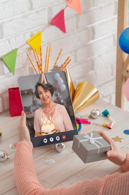 High angle hands holding tablet and gift