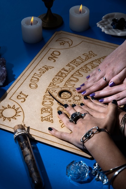 High angle hands touching ouija board