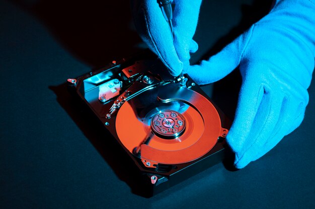 High angle hands with gloves working on hard disk