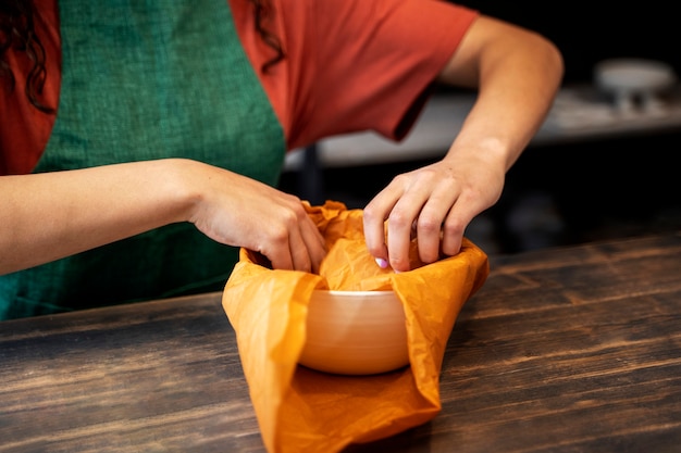 High angle hands wrapping bowl