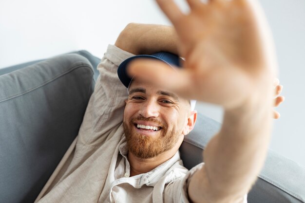 トラッカーハットでポーズをとるハイアングル幸せな男